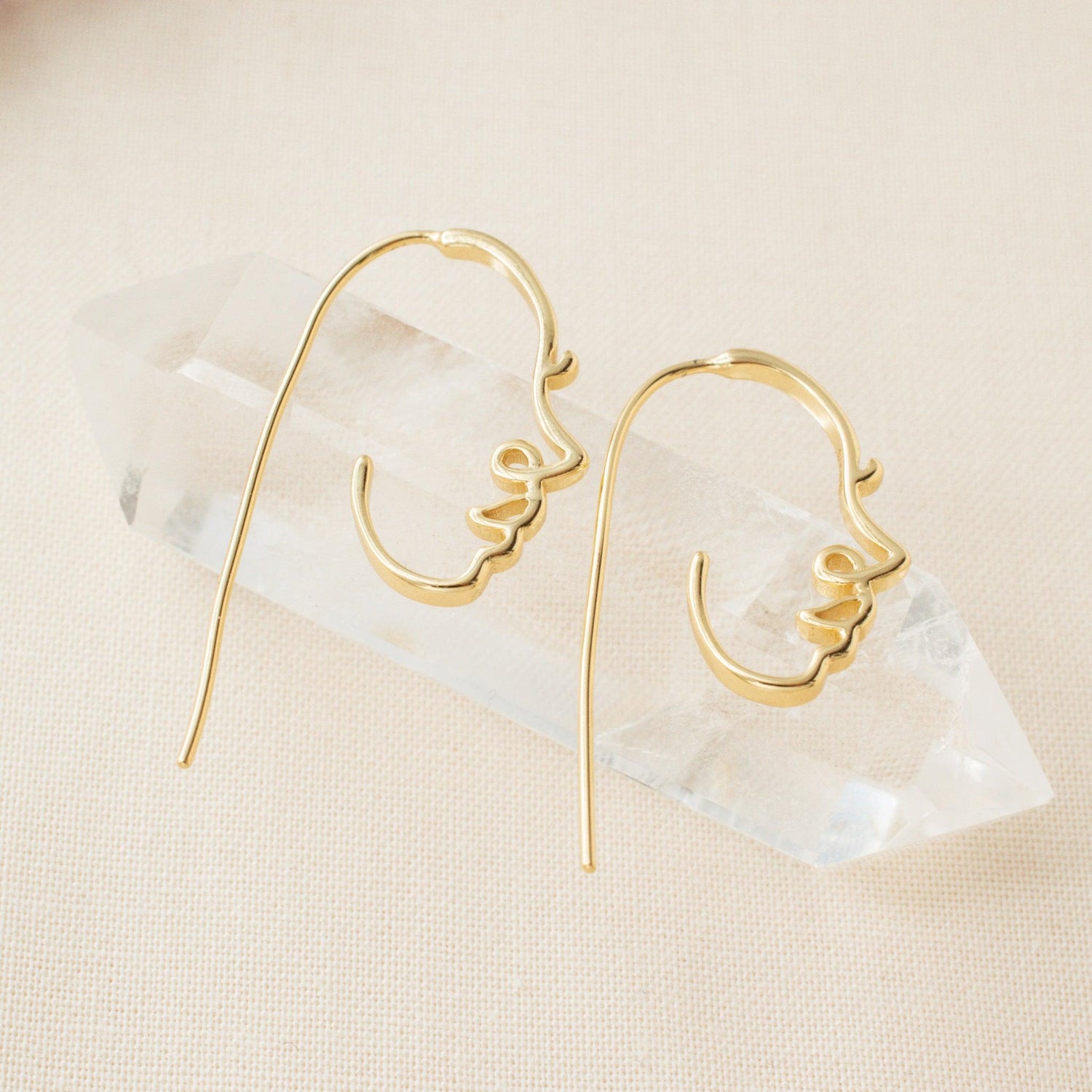 abstract face earrings on a clear crystal 