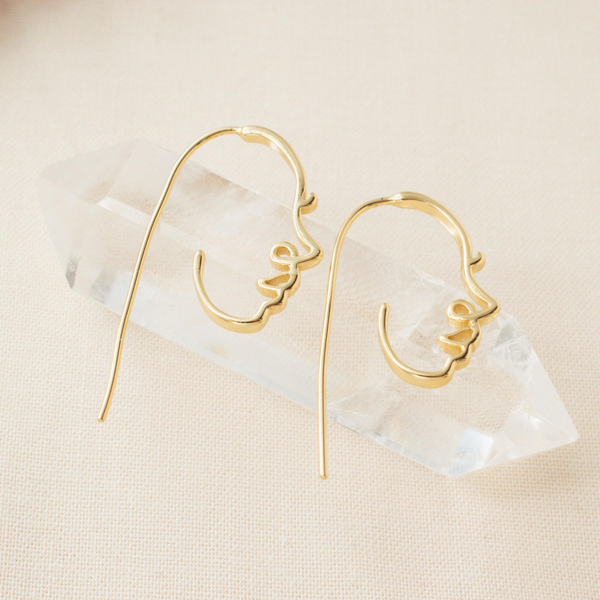 abstract face earrings on a clear crystal 