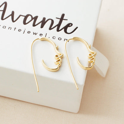 gold face earrings on a Avante jewelry box