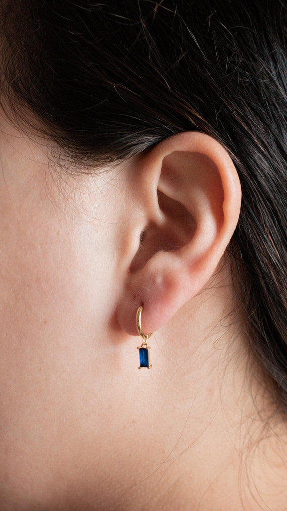 blue baguette dangle earrings on a model