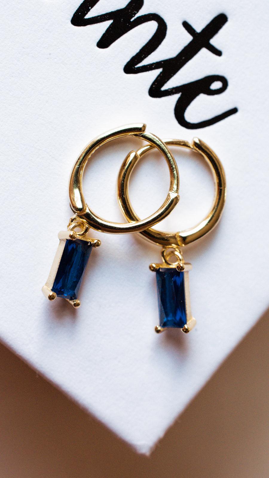 Blue Baguette Dangle Earrings on a white jewelry box 