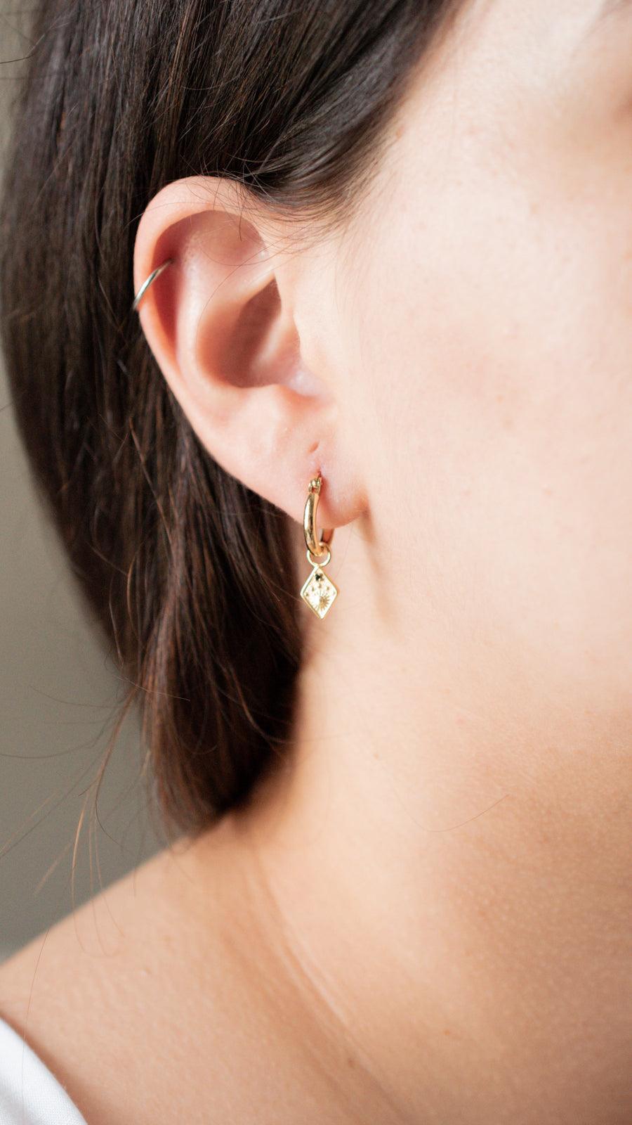 sun hoop earrings on a model