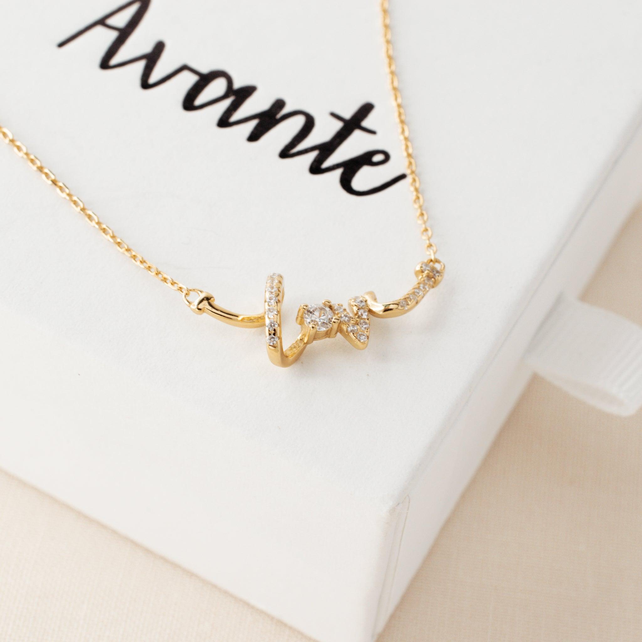 love pendant necklace laying on a jewelry gift box from Avante Jewelry
